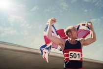 Track and field athlete holding British flag — Stock Photo