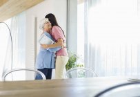 Mother and daughter hugging indoors — Stock Photo