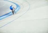 Track cyclist riding around velodrome — Stock Photo