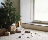 Zuggarnitur und Weihnachtsgeschenke unter Baum — Stockfoto