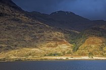 Montagnes vertes et brunes au-dessus du lac, Loch Eilt, Glenfinnan, Écosse — Photo de stock