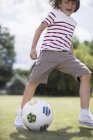 Щасливий хлопчик грає у футбол на відкритому повітрі — стокове фото