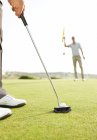 Immagine ritagliata di uomo mettendo pallina da golf — Foto stock