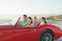 Family in convertible at beach — Stock Photo