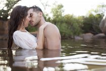 Couple kissing in river during daytime — Stock Photo
