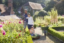 Familie pflückt Blumen im sonnigen Garten — Stockfoto