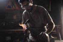 Blacksmith using blowtorch in forge — Stock Photo