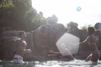 Amici che giocano a calcio nel fiume — Foto stock
