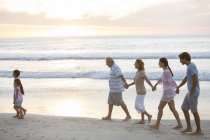 Mehrgenerationenfamilie spaziert am Strand — Stockfoto