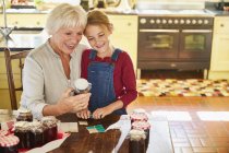 Бабушка и внучка консервируют варенье на кухне — стоковое фото