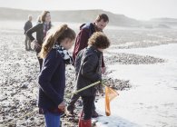 Famiglia multi-generazione clamming sulla spiaggia rocciosa — Foto stock