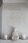 Statuetta di Buddha e candele sul cornicione, primo piano — Foto stock