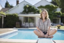 Жінка сидить на трамплін біля басейну — стокове фото