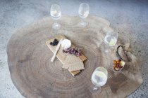 Fruit, cheese and wine on wood log table — Stock Photo