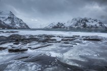 Schneebedeckte Berge hinter kaltem Meer, Vareid, erhabene Inseln, Norwegen — Stockfoto