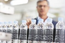 Kontrolleur untersucht Flaschen in Fabrik — Stockfoto