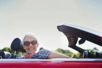 Portrait senior woman driving convertible — Stock Photo