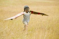 Хлопчик працює з крилами і авіаторів шапка і політ окуляри в галузі — стокове фото