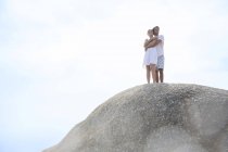 Couple étreignant sur la formation rocheuse — Photo de stock