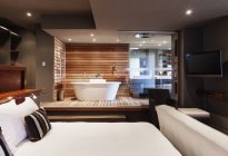Кровать и ванна в современной главной спальне — стоковое фото