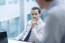 Geschäftsleute reden im Büro, während sie am Tisch sitzen — Stockfoto