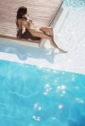 Jovem mulher atraente relaxante por piscina — Fotografia de Stock