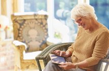 Donna anziana utilizzando tablet digitale — Foto stock