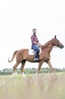 Portrait smiling man horseback riding in rural field — Stock Photo