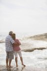 Casal mais velho abraço na praia — Fotografia de Stock