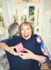 Surprise mature woman receiving gift from husband — Stock Photo