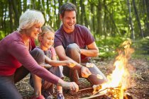 Mehrgenerationenfamilie grillt Marshmallows am Lagerfeuer im Wald — Stockfoto