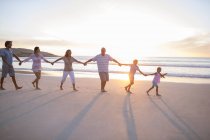 Family holding hands on beach — Stock Photo