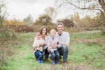 Retrato família sorridente no parque rural — Fotografia de Stock