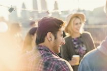 Young adult friends enjoying rooftop party — Stock Photo