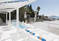 Sillas de salón y piscina con vistas a la playa y al océano - foto de stock