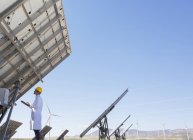 Cientista examinando painel solar na paisagem rural — Fotografia de Stock