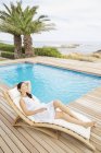 Жінка розслабляється біля басейну вдень — стокове фото