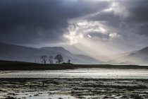 Sonnenstrahlen in stürmischem Himmel über dem See, Schottland — Stockfoto