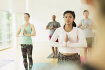 Donna concentrata con le mani in posizione di preghiera in classe di yoga — Foto stock