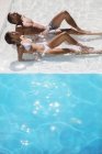 Junges Paar sonnt sich im Schwimmbad — Stockfoto