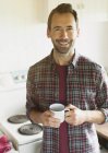 Портрет улыбающийся брюнетка мужчина пьет кофе на кухне — стоковое фото