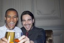 Close up retrato de homens sorridentes brindar cerveja e coquetel — Fotografia de Stock