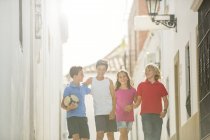 Children with soccer ball walking in alley — Stock Photo