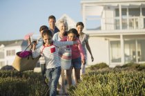 Familie spaziert auf Strandweg vor Haus — Stockfoto