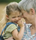 Close up grandmother and granddaughter hugging — Stock Photo
