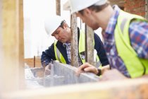 Construction workers examining structure at construction site — Stock Photo