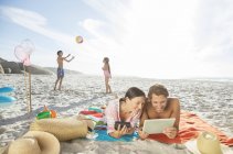 Family relaxing together on beach — Stock Photo