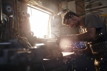 Blacksmith using sander in forge — Stock Photo