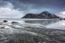 Formation de rochers enneigés sur une plage océanique froide, Skagsanden Beach, Îles Lofoten, Norvège — Photo de stock