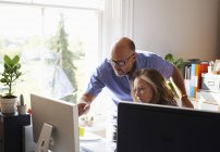 Бизнес-люди, работающие за компьютером в домашнем офисе — стоковое фото